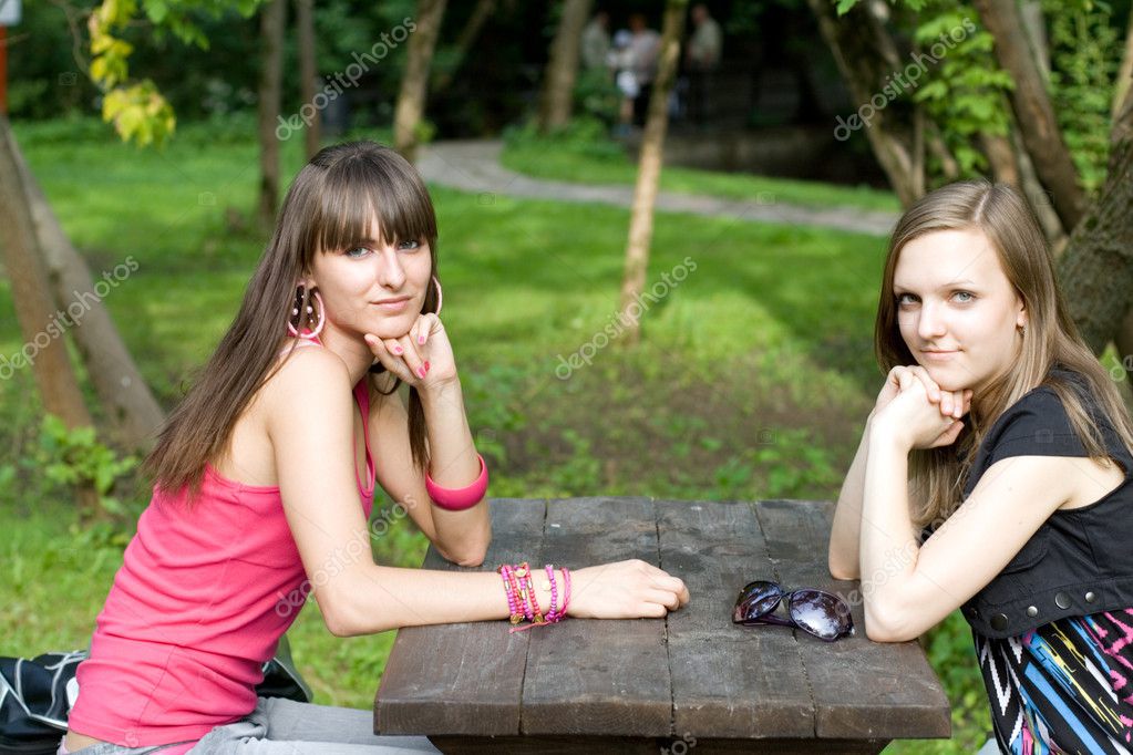 Две подруги уединились на деревянном столе
