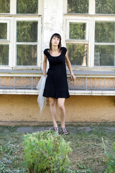Chica de pie frente a una casa vieja —  Fotos de Stock