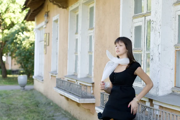 Chica de pie frente a una casa vieja — Foto de Stock