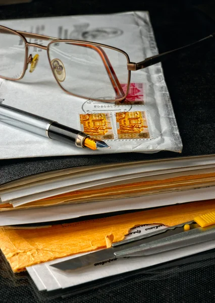 Ручка і окуляри зверху конверта — стокове фото