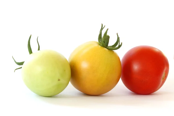 Três tomates tomates coloridos no fundo branco — Fotografia de Stock