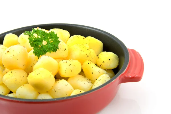 Panela vermelha com batatas assadas frescas — Fotografia de Stock