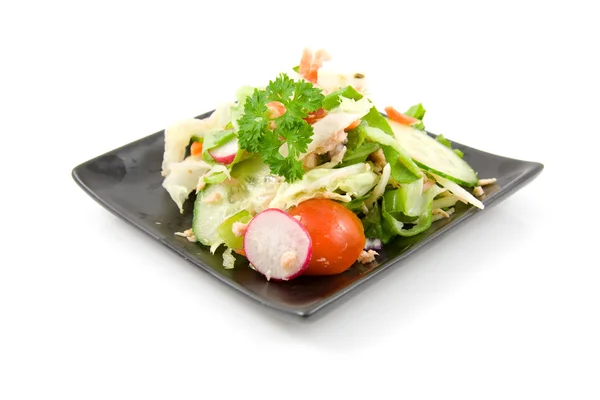 Чорна тарілка зі свіжим салатом — стокове фото