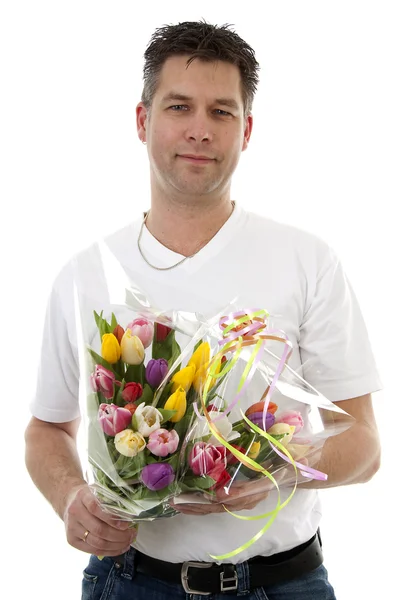 Młody człowiek jest dawanie bukiet tulipanów — Zdjęcie stockowe
