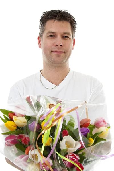 Young man is giving bouquet of tulips — Stock Photo, Image
