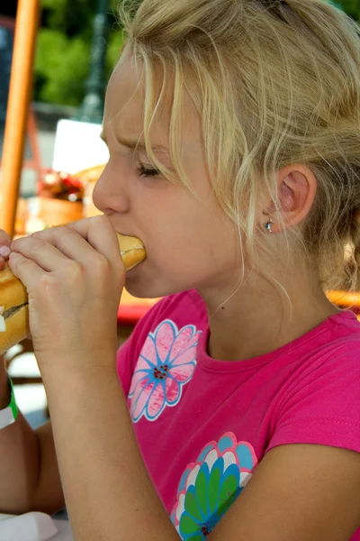 Girl is eating baguette — Stock Photo, Image