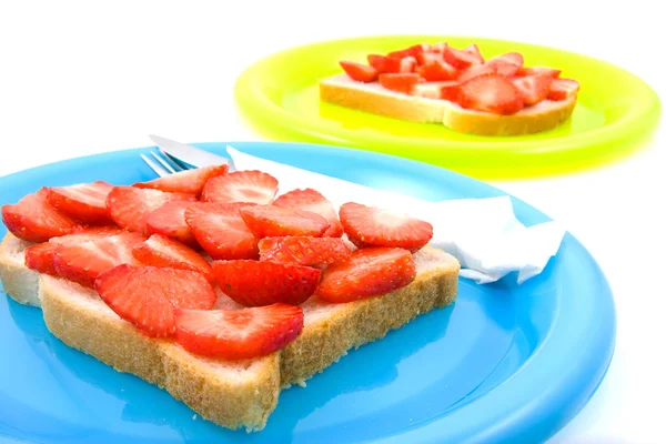 Bread with strawberry on colorful plates — Stock Photo, Image