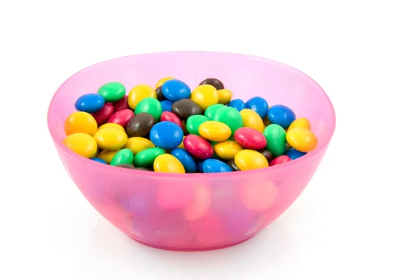 Pink plastic bowl with chocolate candy — Stock Photo, Image