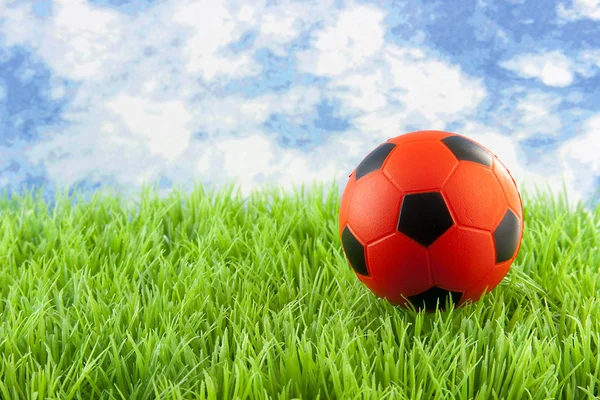 Orangefarbener Fußball auf Gras — Stockfoto