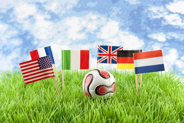 Bandeiras e bola no campo de futebol — Fotografia de Stock
