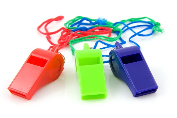 Tři barevné plastové píšťalky — Stock fotografie