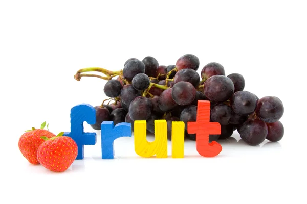 Слово фрукты с виноградом и клубникой — стоковое фото