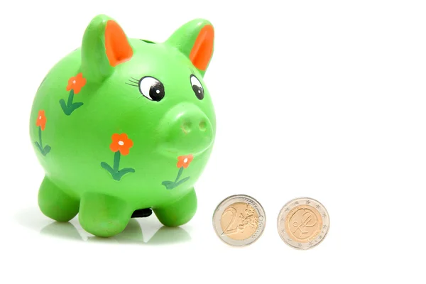 Groene spaarvarken met munten — Stockfoto