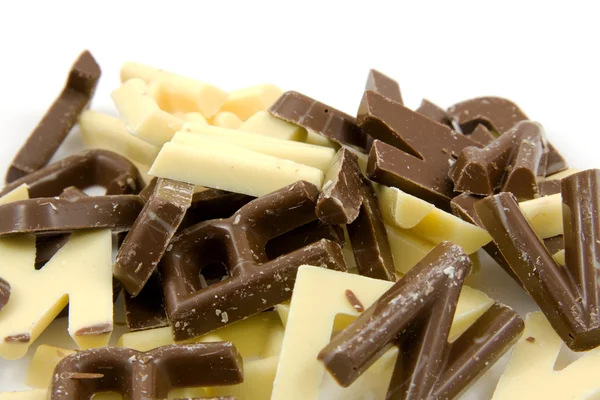 Lettres de bonbons au chocolat blanc et brun à proximité — Photo
