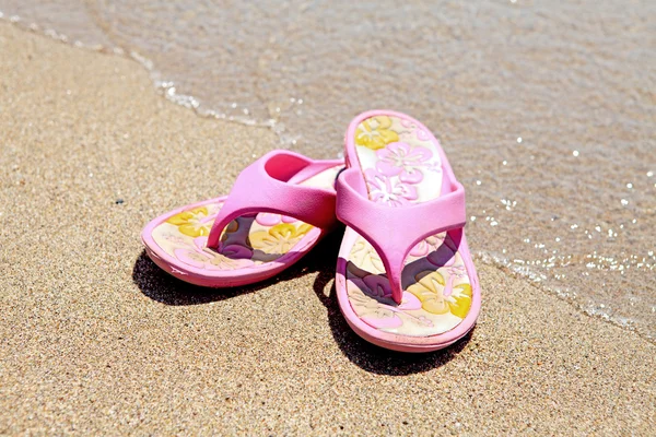 Roze zomer slippers op het strand — Stockfoto