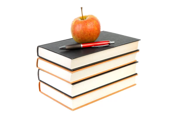 Pila di libri con mela e penna — Foto Stock
