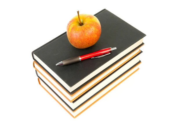 Пачка книг с яблоком и ручкой — стоковое фото