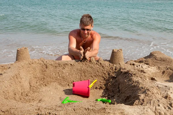 Man is making sandcastle on the beach — Stock Photo, Image
