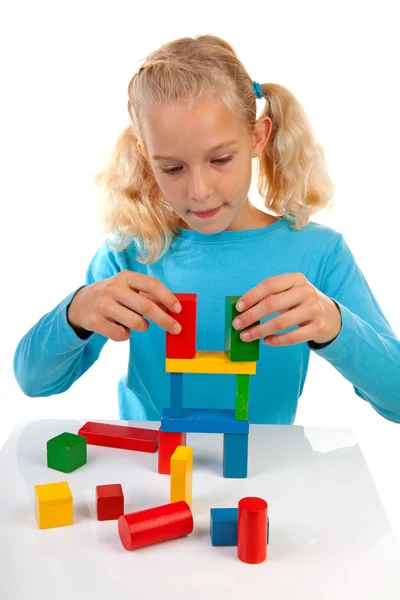 Girl is playing with colorful wooden blocks — Stock Photo, Image