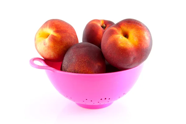 Roze vergiet met perziken — Stockfoto