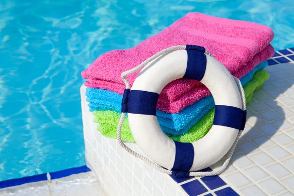 Towels and life buoy near the swim pool — Stock Photo, Image