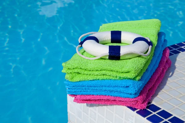 Handtücher und Rettungsring in der Nähe des Schwimmbades — Stockfoto
