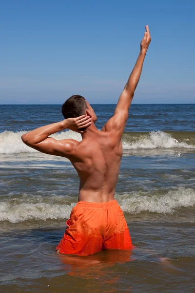The sports young man in the sea Stock Image