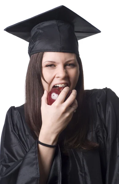 Graduate eating apple — Stock Photo, Image