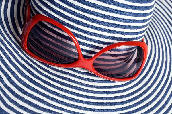 Primo piano di cappello a righe e occhiali da sole rossi — Foto Stock