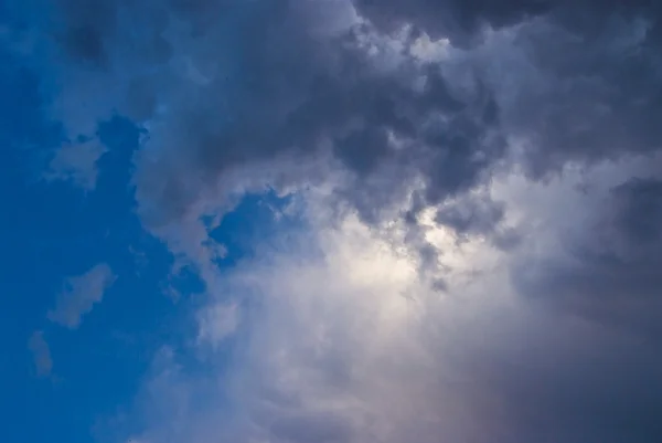 Grijze wolken op blauwe hemel — Stockfoto