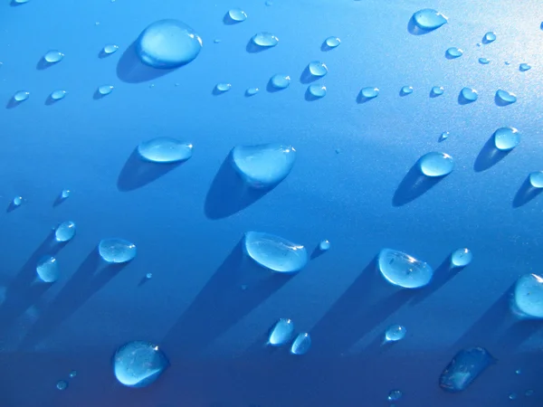 Gotas de agua sobre fondo azul. — Foto de Stock