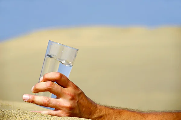Hand and water in desert — Stock Photo, Image