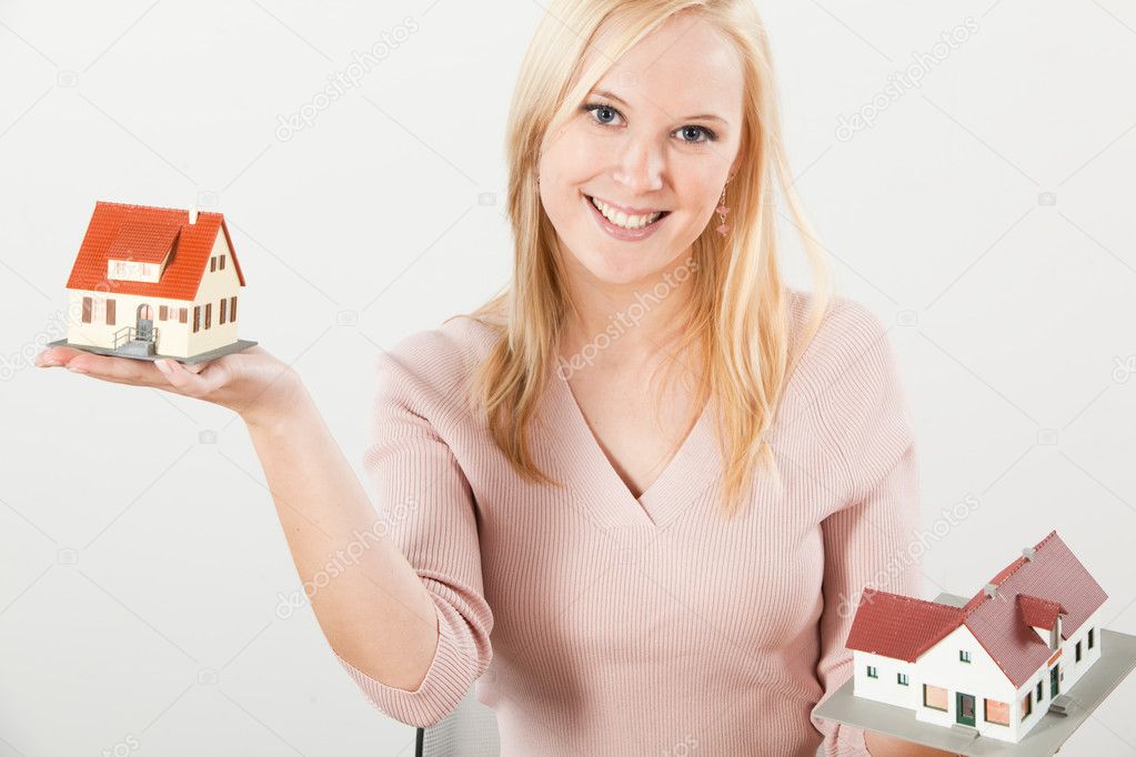 Young woman balancing two houses