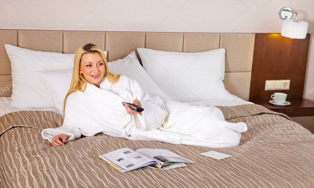 Woman Lying on Bed watching TV