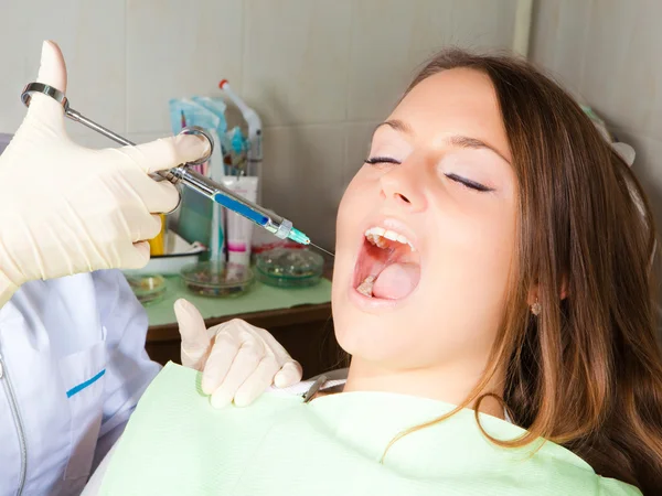 Dentist making shot for woman patient — Stock Photo, Image