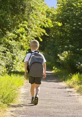 Young boy wearing a backpack clipart