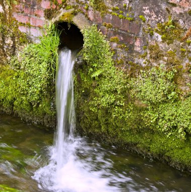 Water pouring from a drainpipe clipart