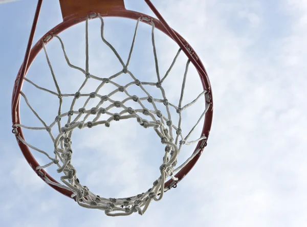 Un aro de baloncesto naranja contra un cielo azul —  Fotos de Stock