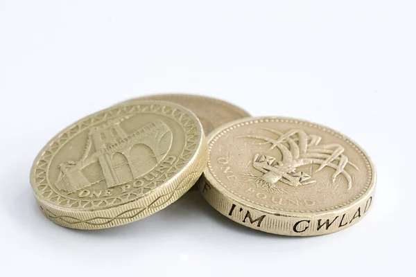Moedas britânicas de uma libra em um fundo branco — Fotografia de Stock