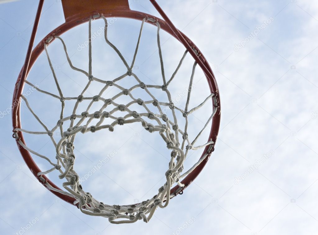 An orange basketball hoop against a blue sky