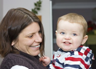 An adorable cute one year old boy with his mother clipart