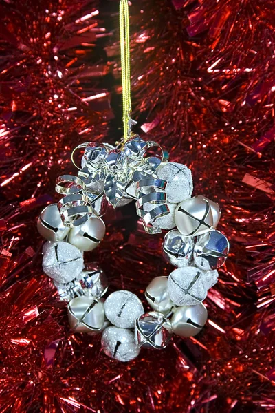 Une décoration de Noël avec des cloches d'argent posées contre certains rouges — Photo