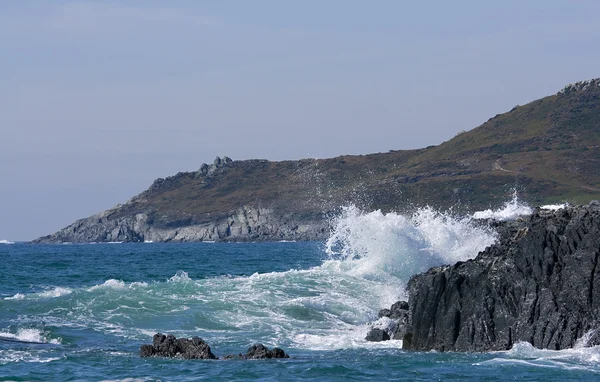 波は岩が多い岬の上にクラッシュ — ストック写真