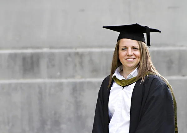 在她的毕业典礼上的骄傲年轻学生 免版税图库照片
