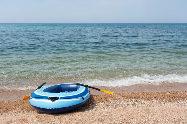 Пляж с резиновой лодкой — стоковое фото