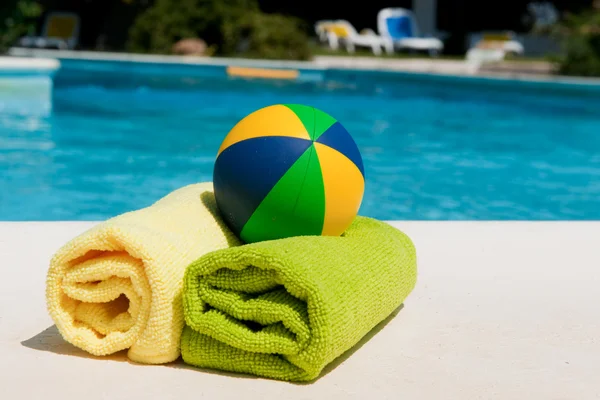 Handdoeken en speelgoed in de buurt van het zwembad — Stockfoto