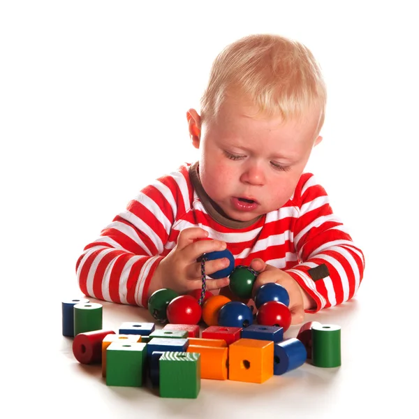 Baby boy is playing with wooden beads — Stock Photo, Image