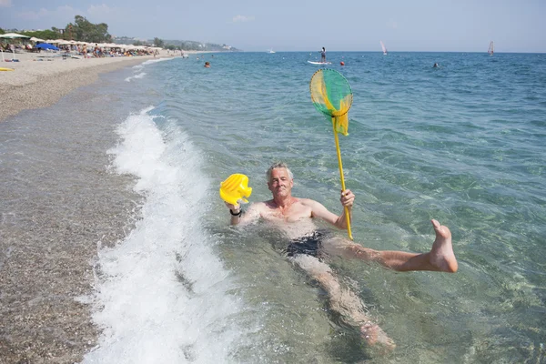 Пожилой человек играет в море — стоковое фото
