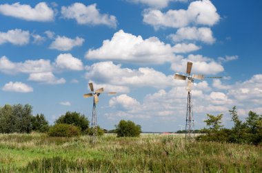 Windmills in summer landscape clipart