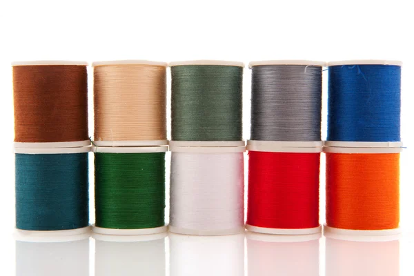 Linhas de costura coloridas em carretéis brancos — Fotografia de Stock